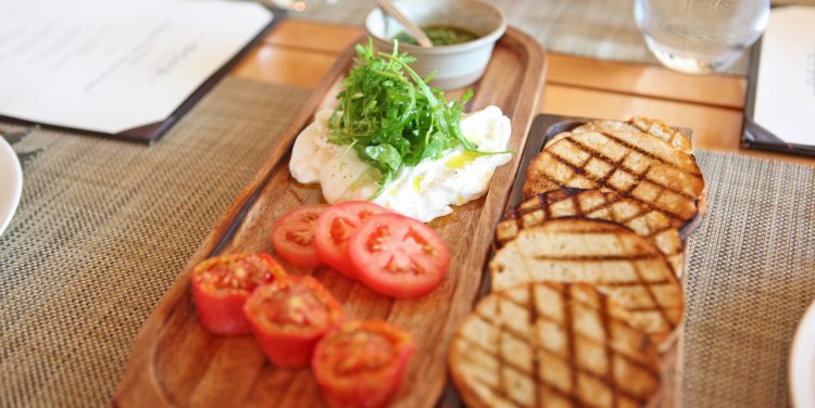 Burrata with fresh and semi-dried tomatoes with rocket pesto