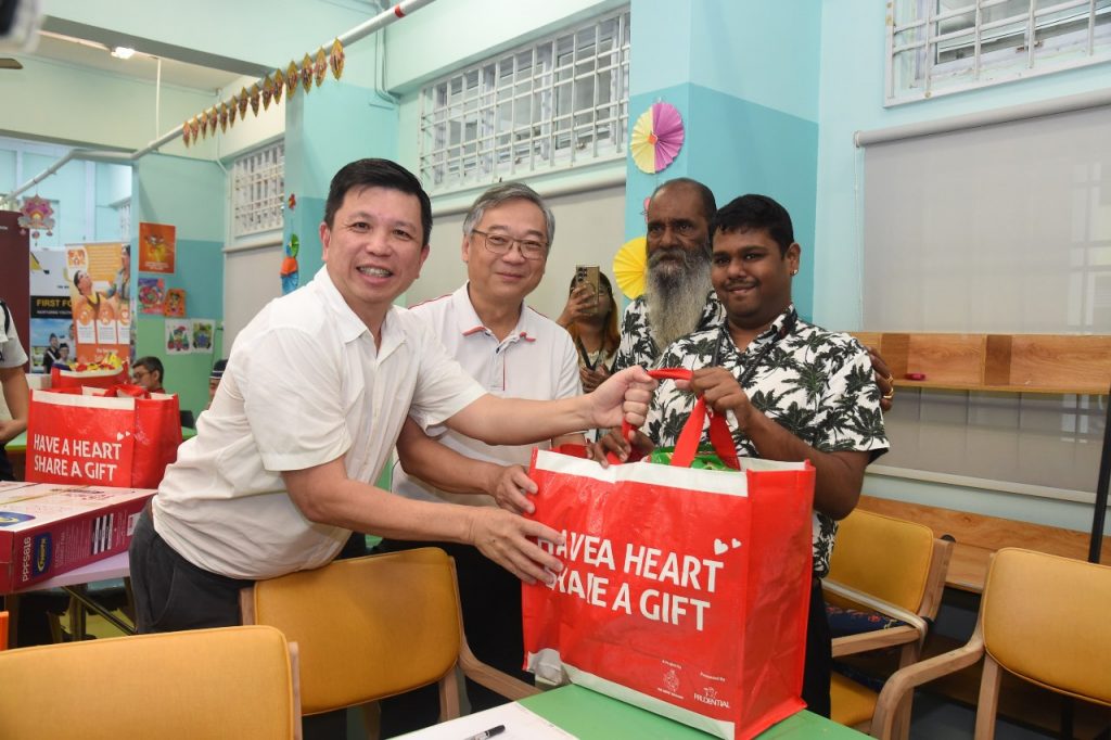 Guest-of-Honor, Mr Gan Kim Yong, Deputy Prime Minister and Minister for Trade and Industry, and Mr Henry Tan, Chairman for The Boys’ Brigade Share-a-Gift (BBSG) 2024 Organising Committee, gifting hampers and Specific Wishes to beneficiaries